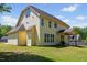 Two-story home featuring yellow siding, a well-manicured lawn and rear patio at 1605 Sassafras St, Durham, NC 27712