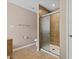 Main bathroom with tiled walk-in shower, neutral tile flooring, and built-in shelving at 1605 Sassafras St, Durham, NC 27712