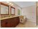 Main bathroom with double vanity, two mirrors, and large soaking tub with tile surround at 1605 Sassafras St, Durham, NC 27712