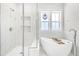 Luxurious main bathroom featuring a soaking tub and walk-in shower with bright natural light at 1709 Chestnut Falls Rd, Wendell, NC 27591