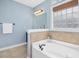 Bathroom features a soaking tub with tile surround, a window for natural light and neutral colored walls at 187 Old Johnson Rd, Wendell, NC 27591