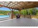 Wooden deck with a grill, an outdoor kitchen area, and a swimming pool in the background at 187 Old Johnson Rd, Wendell, NC 27591