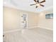 Large main bedroom features a ceiling fan, light wood floors, tray ceiling and an adjoining ensuite bathroom at 187 Old Johnson Rd, Wendell, NC 27591