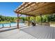 Outdoor kitchen and poolside deck with metal roof, grill, and plenty of seating at 187 Old Johnson Rd, Wendell, NC 27591