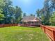 Large backyard with wooden deck, red fence, and mature trees at 19 Rivers Edge Ct, Timberlake, NC 27583