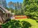 Lush backyard featuring a deck, red fence, and mature trees at 19 Rivers Edge Ct, Timberlake, NC 27583