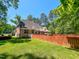 Spacious backyard with a wooden deck, red fence, and a manicured lawn at 19 Rivers Edge Ct, Timberlake, NC 27583