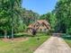 Traditional brick home with a well-manicured lawn, mature trees, and a long driveway at 19 Rivers Edge Ct, Timberlake, NC 27583