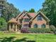 Beautiful brick home featuring a manicured lawn, complemented by lush greenery and mature trees at 19 Rivers Edge Ct, Timberlake, NC 27583