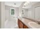 Spacious bathroom featuring double sinks, tile floors, a bathtub, and natural light from multiple windows at 1909 Redding Lane, Durham, NC 27712