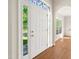 Bright foyer featuring a white door with decorative glass and hardwood floors at 1909 Redding Lane, Durham, NC 27712