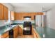 Well-lit kitchen with an island, wood cabinets and stainless steel appliances at 1909 Redding Lane, Durham, NC 27712