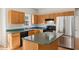 Bright kitchen features wood cabinets and stainless steel refrigerator at 1909 Redding Lane, Durham, NC 27712