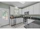 Modern kitchen with stainless steel appliances, granite countertops, and white cabinets at 20 Keswick Ct, Durham, NC 27713
