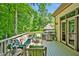 Back deck with patio furniture, a grill, and a view of the property's lush, green surroundings at 20011 Bragg, Chapel Hill, NC 27517