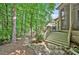 Landscaped backyard features a stone path, trees, and a staircase to a deck space at 20011 Bragg, Chapel Hill, NC 27517