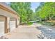 Long driveway leading to a three-car garage, accented by manicured landscaping and mature shade trees at 20011 Bragg, Chapel Hill, NC 27517