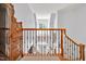 Bright entryway featuring a wooden banister overlooking the front door and a vintage bureau at 20011 Bragg, Chapel Hill, NC 27517