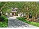 Beautiful home with a long driveway lined with mature trees, leading to a well-manicured lawn and garage at 20011 Bragg, Chapel Hill, NC 27517