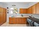 Functional laundry room featuring plentiful wood cabinets, a large stainless steel sink, and a high-efficiency washing machine at 20011 Bragg, Chapel Hill, NC 27517