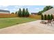 Spacious backyard with a lush green lawn, a paved patio, and a charming outdoor fire pit at 203 Green Pasture Rd, Mebane, NC 27302