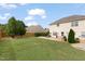 Spacious backyard featuring a concrete patio, fire pit, well-maintained lawn, and privacy fence at 203 Green Pasture Rd, Mebane, NC 27302