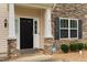 Close up of the entryway with stone accents and a black front door at 203 Green Pasture Rd, Mebane, NC 27302