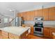 Well-lit kitchen featuring stainless steel appliances, wooden cabinetry, and a center island with seating at 203 Green Pasture Rd, Mebane, NC 27302