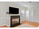 Living room with a fireplace, a large TV, built-in white shelving, and hardwood floors at 203 Green Pasture Rd, Mebane, NC 27302