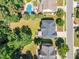 An aerial view shows a backyard with a wooden deck, plus a community pool surrounded by lush green trees at 2049 Rainy Lake St, Wake Forest, NC 27587