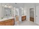 Double vanity bathroom with granite counters, wood cabinets, and bright lighting at 2049 Rainy Lake St, Wake Forest, NC 27587