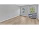 Bright bedroom with two windows offering views of mature trees and new wood floors at 2049 Rainy Lake St, Wake Forest, NC 27587