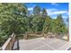 A spacious outdoor deck features wooden railings and a beautiful view of the lush, green trees and landscaping at 2049 Rainy Lake St, Wake Forest, NC 27587