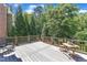 A private outdoor deck area features wood railings, a cozy spot with table and chairs, and a beautiful treed backdrop at 2049 Rainy Lake St, Wake Forest, NC 27587
