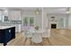 A dining area with a white table, chairs, and access to the backyard, adjacent to a kitchen with white cabinetry at 2049 Rainy Lake St, Wake Forest, NC 27587