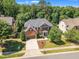 Two-story brick home with a grey roof, trimmed lawn, a paved drive leading to a two car garage, and mature landscaping at 2049 Rainy Lake St, Wake Forest, NC 27587