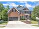 Elegant brick home featuring a two-car garage, manicured lawn, and classic black shutters at 2049 Rainy Lake St, Wake Forest, NC 27587