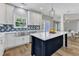 Bright kitchen with white cabinets, an island with a white countertop, and stainless steel sink at 2049 Rainy Lake St, Wake Forest, NC 27587