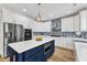 A modern kitchen with white cabinets, stainless steel appliances, and a blue island at 2049 Rainy Lake St, Wake Forest, NC 27587