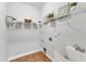 Bright laundry room with storage shelves, tile flooring, and utility sink at 2049 Rainy Lake St, Wake Forest, NC 27587