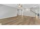 Open-concept living room with hardwood floors, a ceiling fan, and access to the upper floors via the staircase at 2049 Rainy Lake St, Wake Forest, NC 27587
