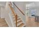 Staircase with wooden handrails leading to an open living area with natural light at 2049 Rainy Lake St, Wake Forest, NC 27587