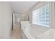 Bright bathroom showcases a soaking tub under a window and tile flooring at 210 Mediate Dr, Raleigh, NC 27603