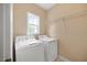 Bright laundry room with a washer, dryer, and wire rack shelving at 210 Mediate Dr, Raleigh, NC 27603
