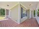 Relaxing covered porch with wood flooring, white railings and green siding at 210 Mediate Dr, Raleigh, NC 27603