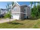 Charming two-story townhome featuring a one-car garage and manicured lawn at 212 Brook Farm Ln, Fuquay Varina, NC 27526