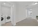 Open hallway featuring tile and carpet flooring and a laundry room with washer and dryer at 212 Brook Farm Ln, Fuquay Varina, NC 27526
