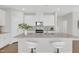 Bright kitchen featuring an island with granite countertops and modern white cabinetry at 212 Brook Farm Ln, Fuquay Varina, NC 27526