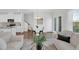 Bright living room features modern decor, hardwood floors, neutral walls, and a view into the kitchen at 212 Brook Farm Ln, Fuquay Varina, NC 27526