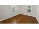 Bright bedroom features hardwood floors and two windows, offering ample natural light at 215 Westridge Dr, Raleigh, NC 27609